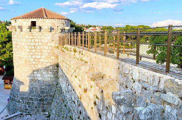 Krk town, Krk, Croatia - August 22, 2015: The round venetian tower of Frankopan Castle, at Kamplin square in Krk, Croatia - Frankopanski Kastel, part of the medieval city walls and conical canon openings