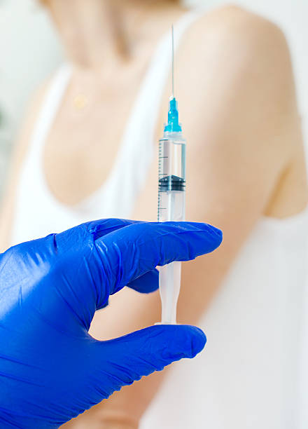 istock Doctor's hand holding syringe with injection. 628470550