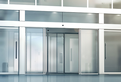 Blank sliding glass doors entrance mockup, 3d rendering. Commercial automatic slide entry mock up. Office building exterior template. Closed transparent business centre facade, front view.