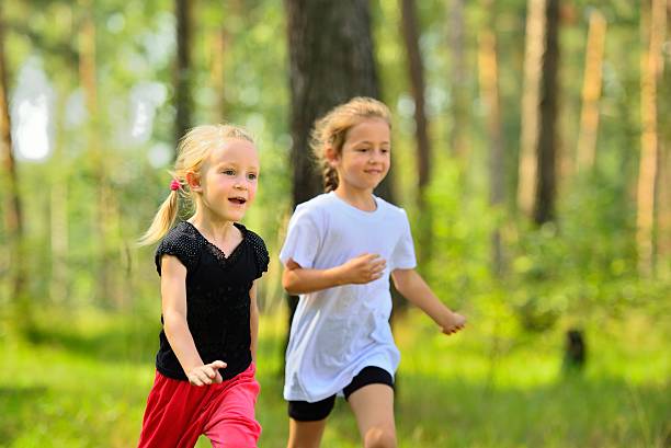 istock Two little cute girls jogging in forest 628481306