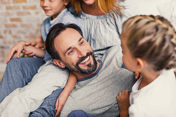 istock Happy family lying down on bed at home 628482990