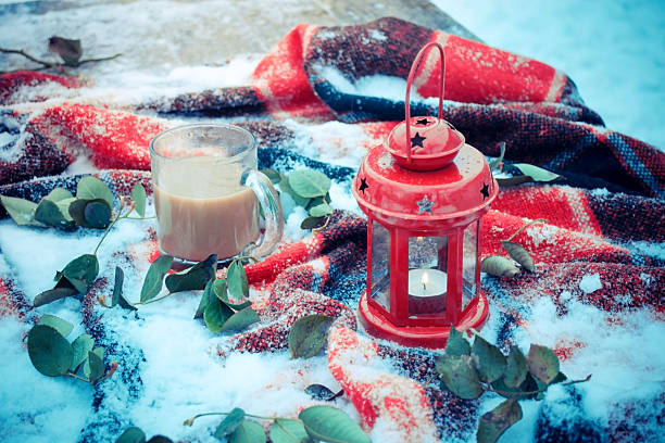 istock Festive red candle in lantern and mug of coffee on 628483932