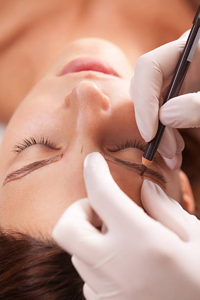 istock Beautiful woman in beauty salon on permanent eyebrow makeup trea 628489838