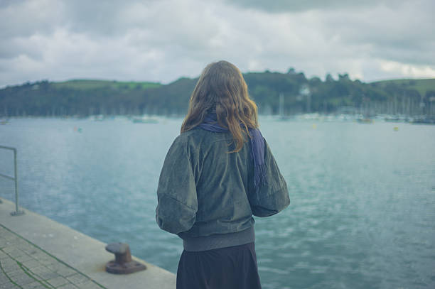 istock Woman walking by river in small town 628490524