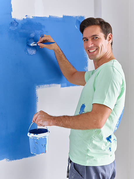 istock Man painting wall with a brush 628496574
