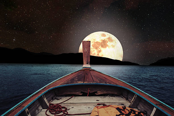 Traveling on wooden boat at night with full moon Traveling on wooden boat at night with full moon and stars on sky. romantic and scenic panorama with full moon on sea at night moonlight photos stock pictures, royalty-free photos & images