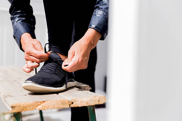 istock Low section of female athlete tying shoelace 628504780