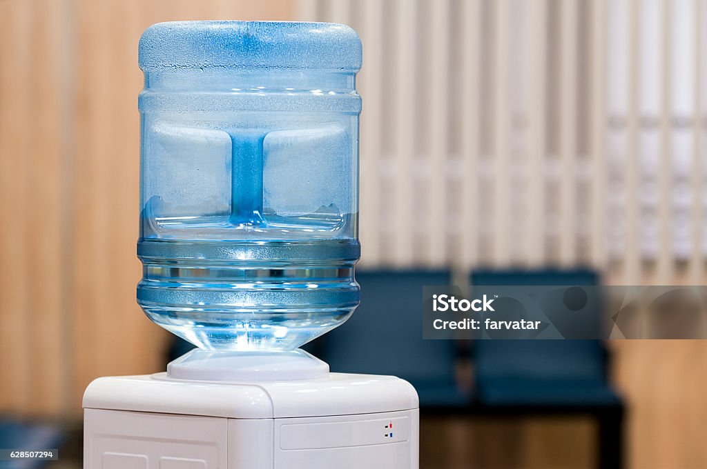 Water gallon on water cooler Blue water gallon on water cooler in office Gallon Stock Photo