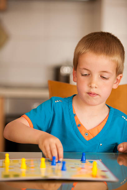 istock young boy plays ludo game on a table in livingroom 628508574