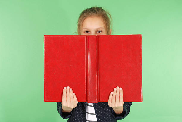 istock Young school girl with red book 628517038