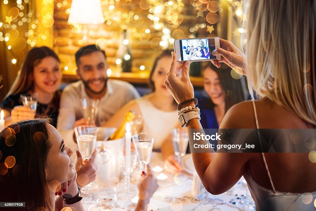 Christmas party Friends celebrating Christmas or New Year eve. Party table with champagne. Adult Stock Photo