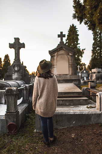A young woman visiting a tombstone at a cemetery