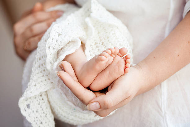 mother 手を赤ちゃんの足を包みます。母と彼女の子ます。 - beautiful human toe human foot human leg スト�ックフォトと画像