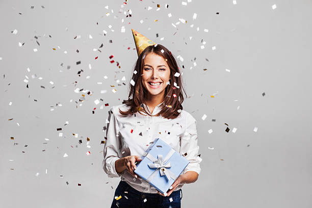 istock Laughing girl with falling confetti at party 628525646