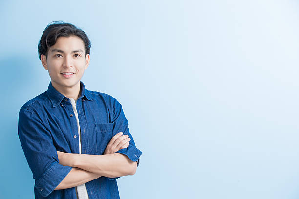man student smile to you man student smile to you isolated on blue background,asian male chinese student stock pictures, royalty-free photos & images
