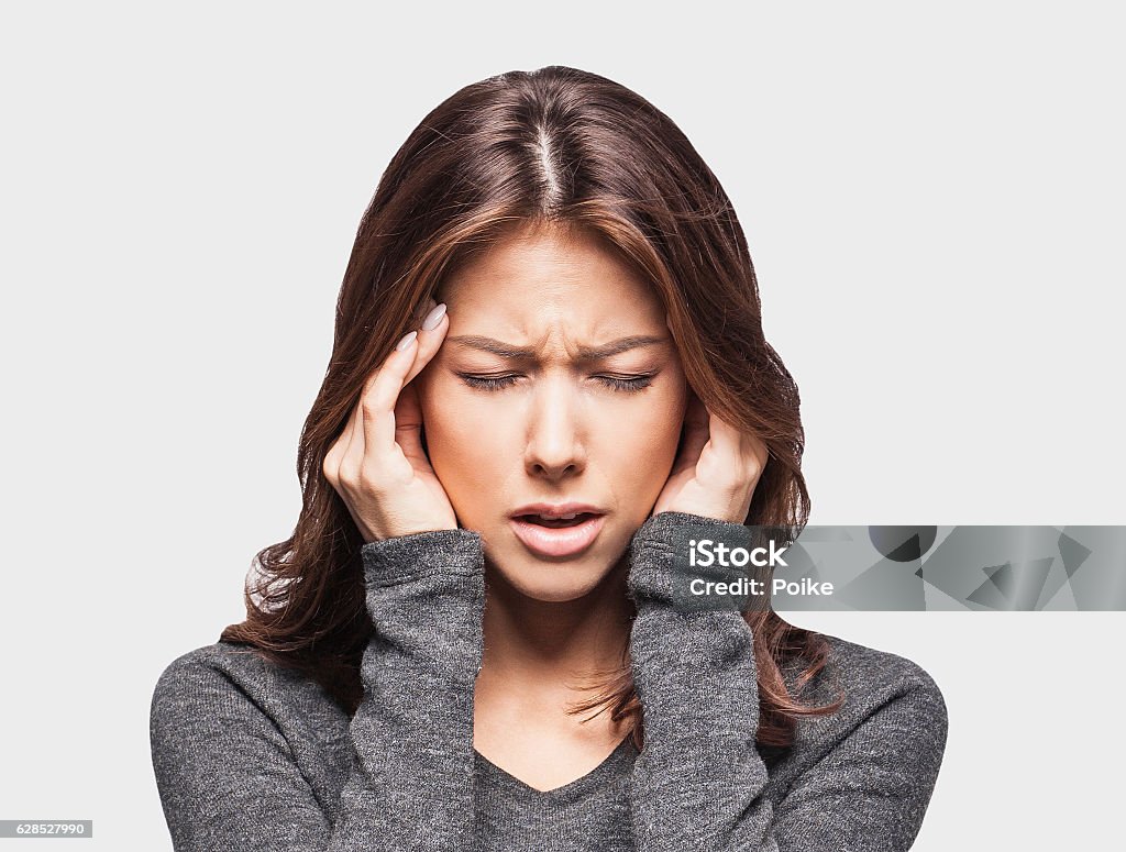 Young woman having a headache Young woman having headache and holding hands on temples Women Stock Photo