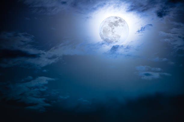 istock Nighttime sky with clouds and bright full moon with shiny. 628536792