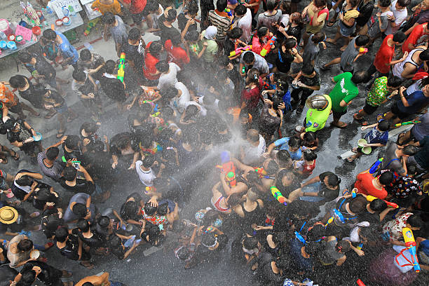 People celebrating the Songkran New Year Festival in Bangkok, Thailand. BANGKOK - APRIL 13: Crowd of people celebrating the traditional Songkran New Year Festival, April 13, 2014, Silom road, Bangkok, Thailand. silom stock pictures, royalty-free photos & images