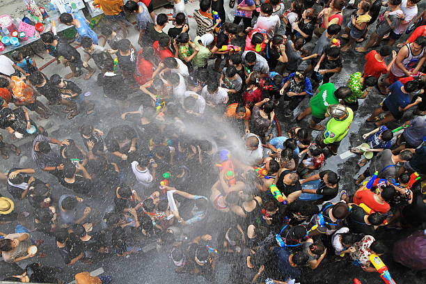 People celebrating the Songkran New Year Festival in Bangkok, Thailand. BANGKOK - APRIL 13: Crowd of people celebrating the traditional Songkran New Year Festival, April 13, 2014, Silom road, Bangkok, Thailand. silom stock pictures, royalty-free photos & images