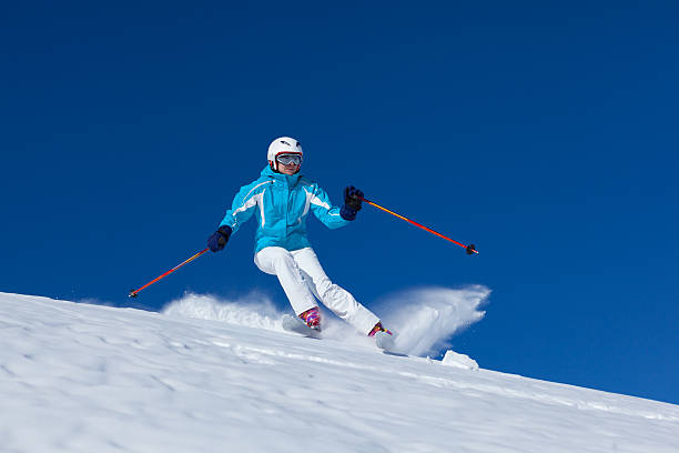 skier is riding from snow hill in the sun beam very fast