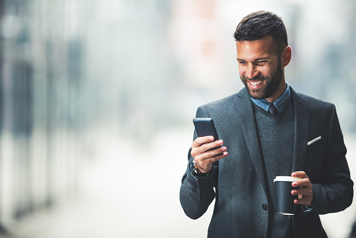 Handsome businessman using a mobile phone during the coffee break.