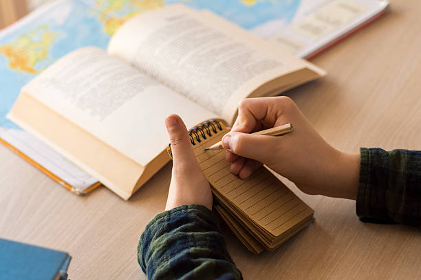 istock Young Schoolboy Writing on Notebook and Studying on Desk 628541152
