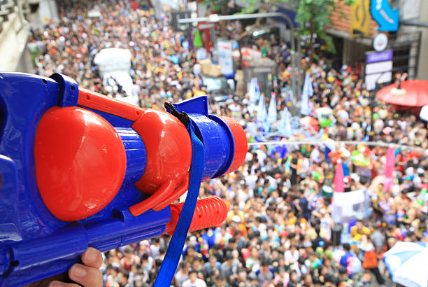 People celebrating the Songkran New Year Festival in Bangkok, Thailand. BANGKOK - APRIL 13: Crowd of people celebrating the traditional Songkran New Year Festival, April 13, 2014, Silom road, Bangkok, Thailand. silom stock pictures, royalty-free photos & images