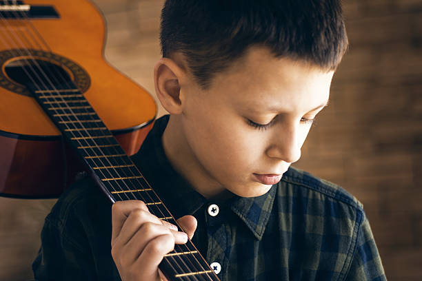 istock Sad Thoughtful Boy With Acoustic Guitar on His Shoulder 628541948