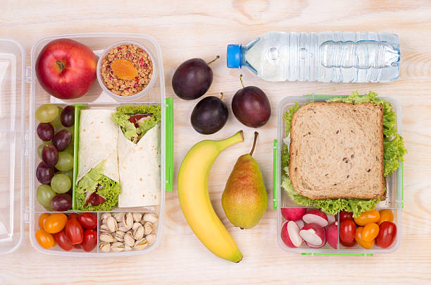 istock Lunchboxes with sandwiches, fruits, vegetables, and water 628547702