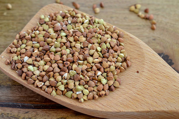 istock Buckwheat in wooden spoon on wood background 628548632