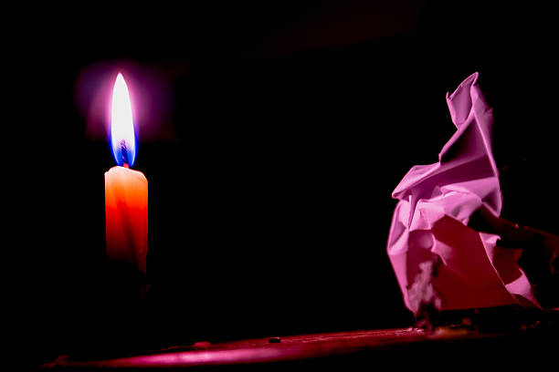 Concept of Candle flame light at night with paper and abstract black background. Soft Focus