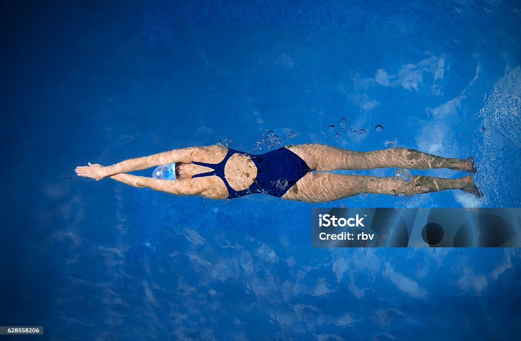 Young woman swimmer Young woman swimmer in blue pool water Swimming Stock Photo