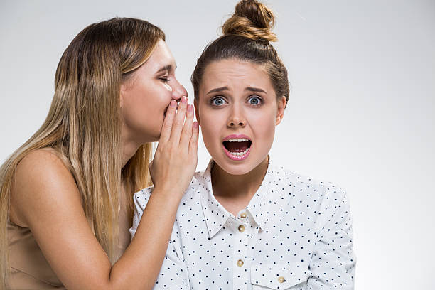 istock Two girls gossiping, one is terrified 628561484