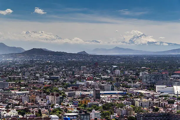 south west part of metropolitan area of mexico, with mountainrange of two snowed vulcanoes in the back