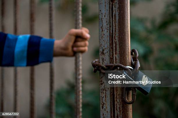 Unrecognizable Person Holding Locked Door Stock Photo - Download Image Now - Slavery, A Helping Hand, Adolescence