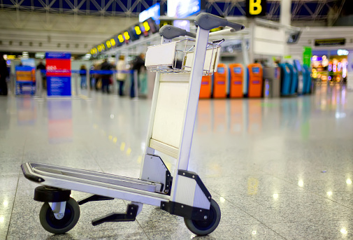 Empty metal cart for luggage standing at airport. Travel concept. Nobody.