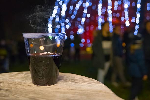 tasse heißer glühwein auf dem tisch und verschwommene lichter - brule stock-fotos und bilder