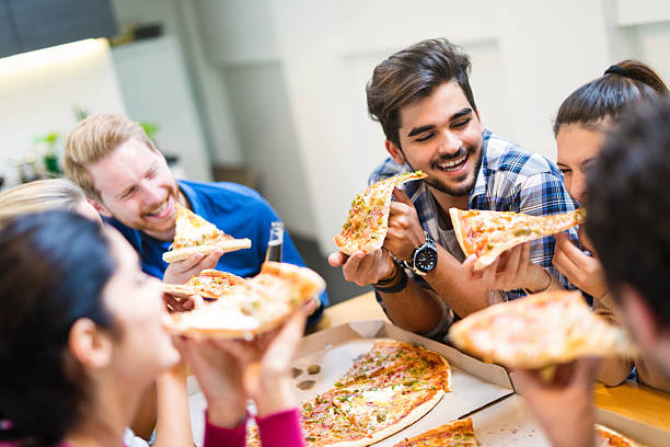 amigos que tienen fiesta con pizza, cerveza y buena compañía - pizza party fotografías e imágenes de stock