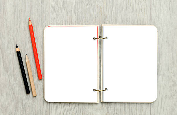 istock Opened blank notepad with colorful pencils on wooden table 628595328