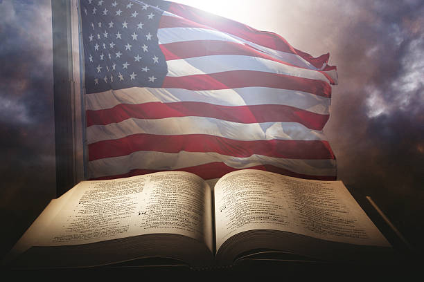 holy bible with the american flag - testaments imagens e fotografias de stock