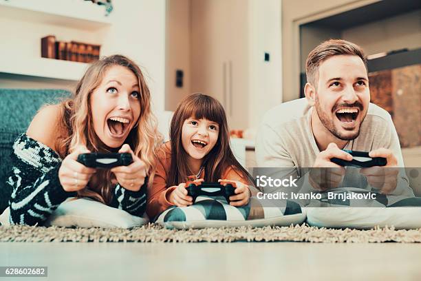 Competitive Family Playing Video Games At Home Stock Photo - Download Image Now - Family, Video Game, Gambling