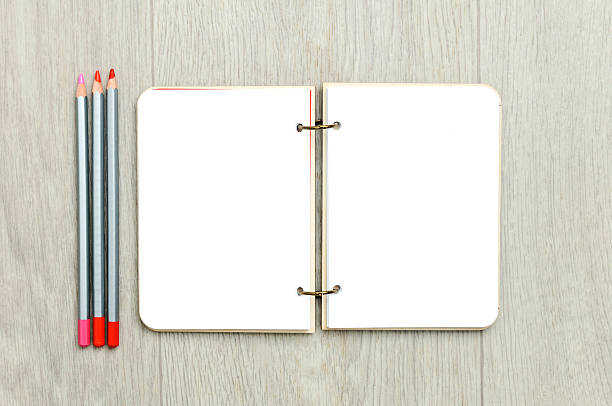 istock Opened blank notepad with colorful pencils on wooden table 628606836