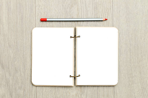 istock Opened blank notepad with colorful pencils on wooden table 628606956