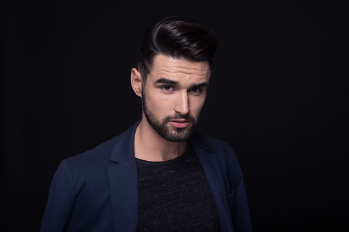young adult man 20s, fashion model, headshot, head face, good looking sharp. Wearing casual clothes, suit. Black background, studio.