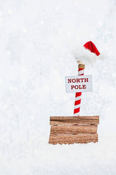 istock Santa's hat atop the North Pole with blank sign 628607414