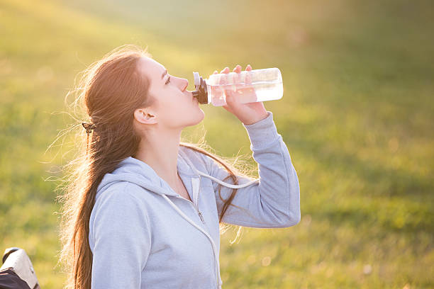 istock young sportive woman drinking water at sunset 628607844