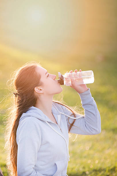 istock young sportive woman drinking water at sunset 628607932