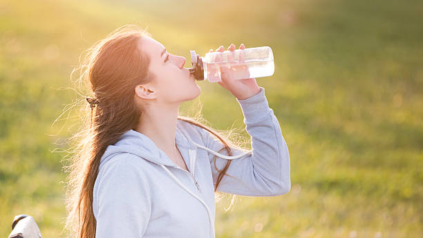 istock young sportive woman drinking water at sunset 628608110