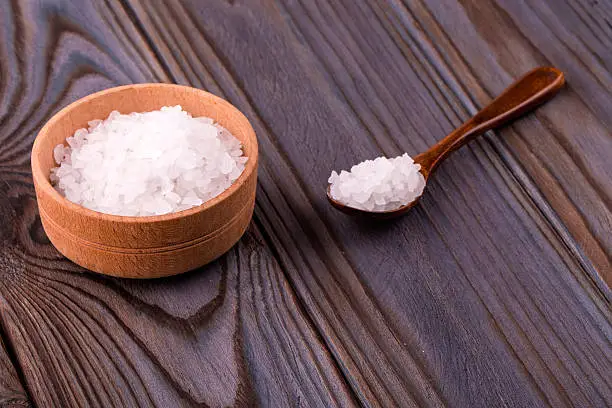 Photo of White bath salt in a wooden bow