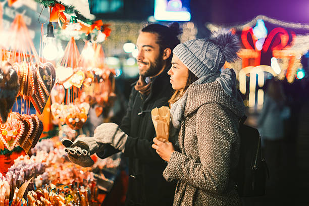 junges paar mit spaß im freien zur weihnachtszeit - straßenmarkt stock-fotos und bilder